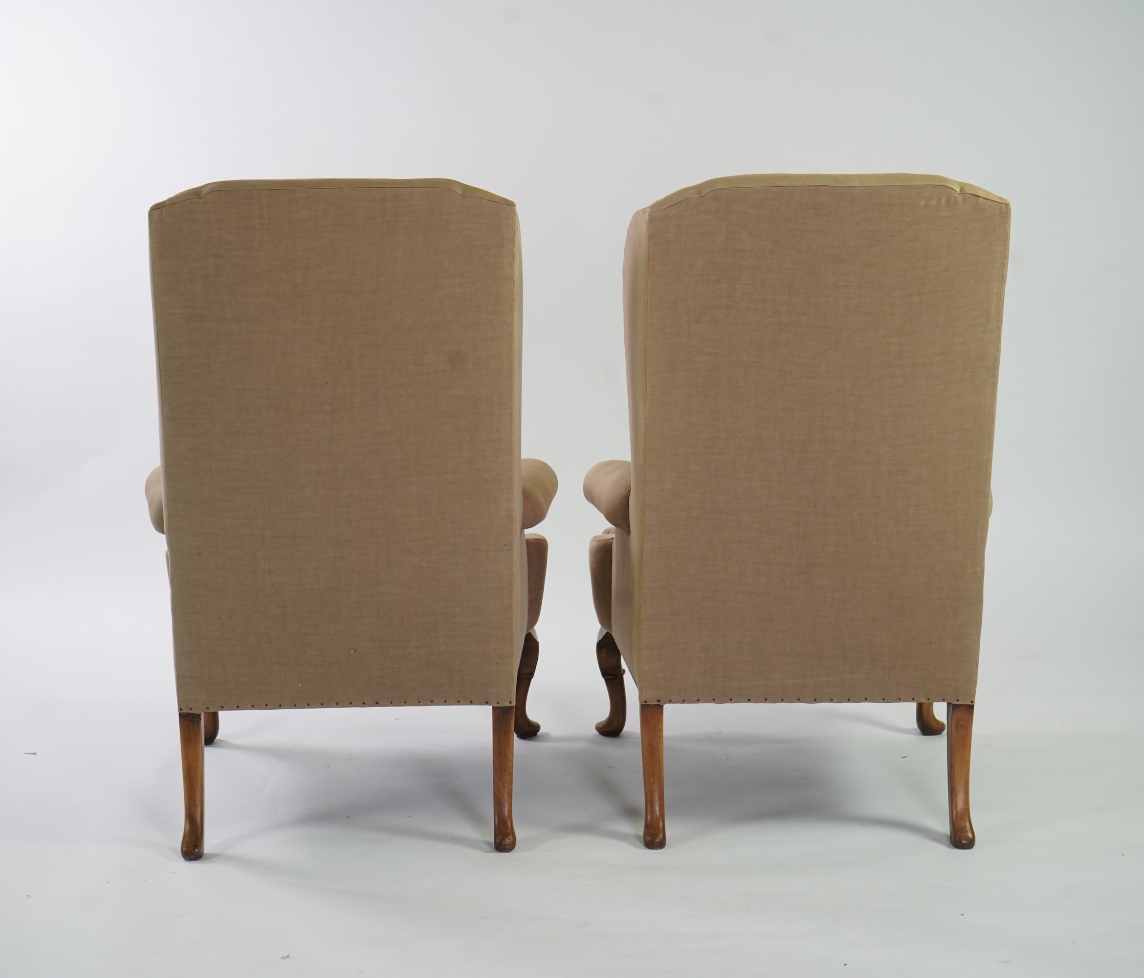 A pair of late 19th / early 20th century George II style upholstered wing armchairs
